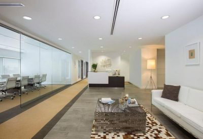 Minimalist reception area with a white front desk and glass-walled meeting room.