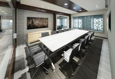 Sleek modern boardroom with a long white table and grey ergonomic chairs.
