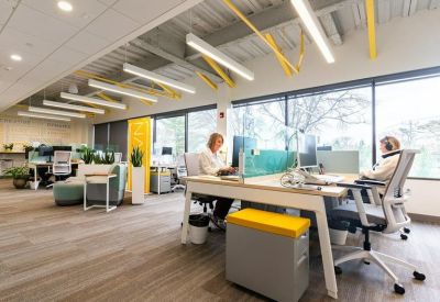 Modern workspace featuring shared desks and yellow storage cabinets.