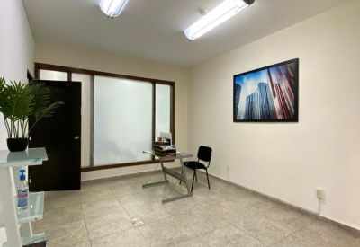 Bright private office featuring a glass desk, modern artwork, and tile flooring.
