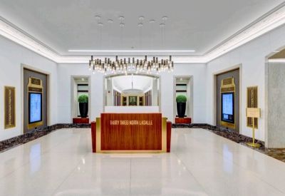 Sleek modern reception lobby with a wood-panelled desk and digital building directories.