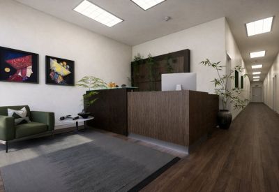 Reception area with a dark wood desk, green armchair, and modern wall art.