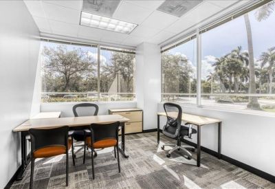Private office suite with two desk setups and floor-to-ceiling windows.