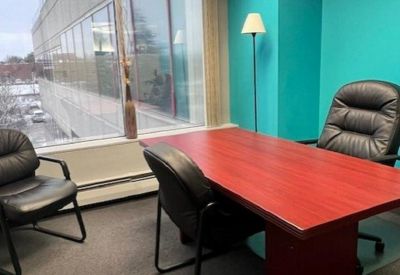 Private office featuring a red desk and a bright turquoise accent wall by a large window.