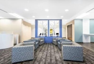 Modern reception lounge area with patterned grey armchairs and blue wall accents.