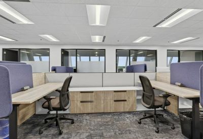 Modern open-plan workspace with multiple desks and ergonomic chairs.