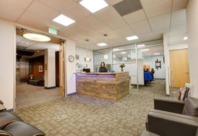 Spacious reception lobby with a modern wood-paneled desk and warm lighting.