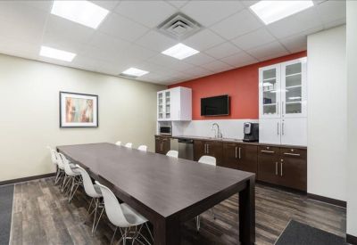 Kitchen and breakout area featuring a long communal table and red accent wall.
