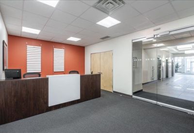 Reception area with dark wood desk and vibrant orange feature wall.