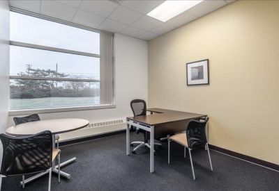 Private office with a large window and a small meeting table.