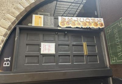 Dark paneled entrance door with a decorative welcome sign and unit B1 label.