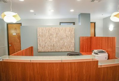 Reception area with a wood-paneled desk and modern pendant lighting.