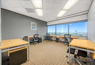 Shared office suite with multiple desks and expansive window views.