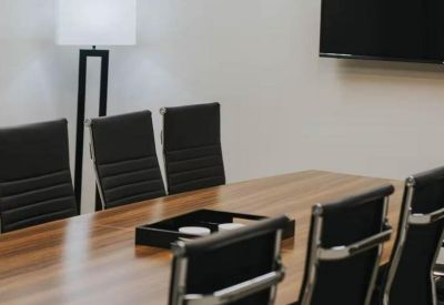 Close-up of black leather chairs and a wooden conference table.