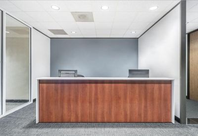 Professional reception desk with wood paneling in front of a blue feature wall.