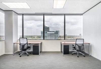 Private office featuring two desks facing a wall of windows with city views.