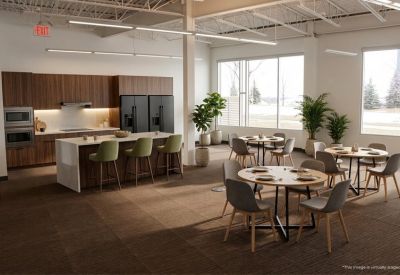 Modern cafeteria and kitchen area with wooden cabinetry and green bar stools.