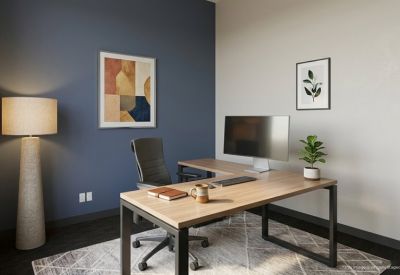 Private office featuring an L-shaped wooden desk and a blue accent wall.