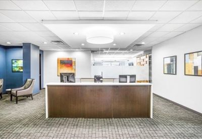 Modern reception area with a dark wood desk and vibrant abstract artwork.