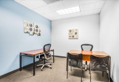 Private office with two wood-finish desks and an accent wall in light blue.