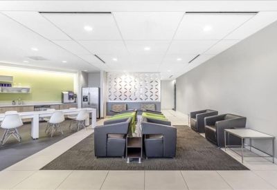 Modern breakout area with a coffee bar, lounge seating, and lime green accents.