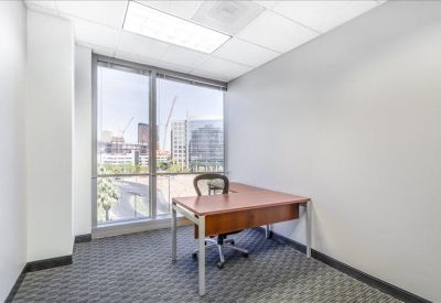 Private office with a single wooden desk and views of the city skyline.