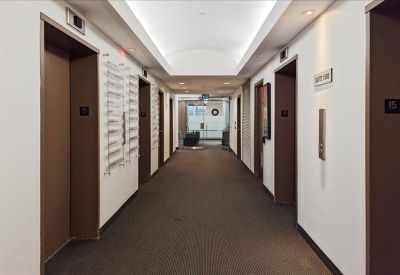Professional building corridor leading to office suites with elevator access.