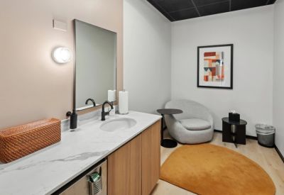 Comfortable wellness or break room with a plush grey chair, marble countertop, and warm rug.