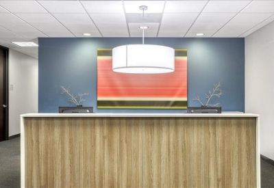 Modern reception desk with a wood-slat front and vibrant orange wall art.