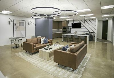 Spacious lounge area with leather couches, unique circular light fixtures, and a polished floor.