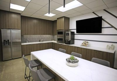 Contemporary office breakroom with wood cabinets, high-end appliances, and a large kitchen island.