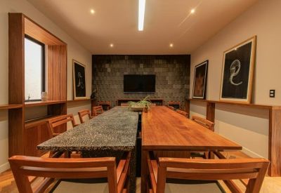 Spacious boardroom with a large wooden table, textured accent wall, and framed art.