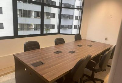 Conference room with a large wooden table and views of neighboring buildings through large windows.