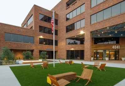 Outdoor lounge with chairs and potted plants on a sunny terrace.