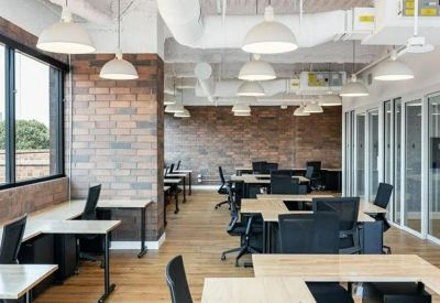 Open-plan workspace with brick walls and large windows.
