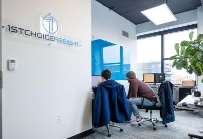 Coworking area featuring a branded glass wall and workstations.