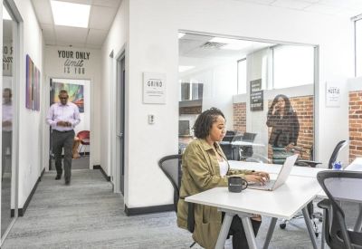 Hallway leading to bright offices with a motivational wall decal.