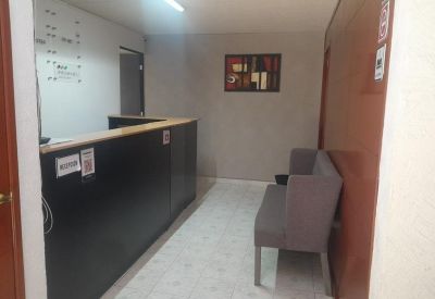 Professional reception area with a dark wood-paneled desk and grey guest seating.