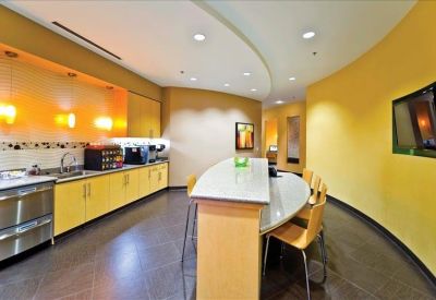Communal kitchen and break area with yellow cabinetry and a curved dining bar.