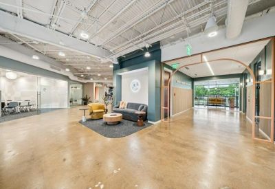 Wide-angle view of an open reception area with polished floors and contemporary seating.