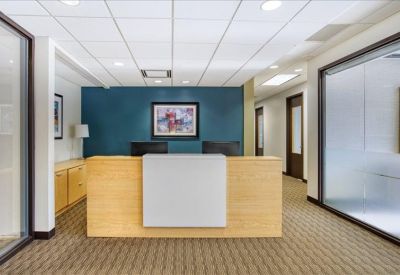 Reception desk with a light wood finish and a blue branded wall.