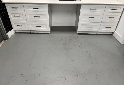Close-up of white office cabinetry and grey flooring.