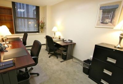 Private office suite with two wood desks and a view through the window.