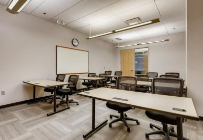 Classroom-style training room with multiple rows of desks and black mesh chairs.