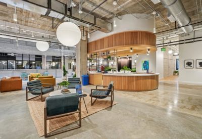 Reception area with a curved wooden desk, globe lights, and vibrant artwork.
