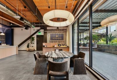 Reception area with a large circular light fixture and branded wall.