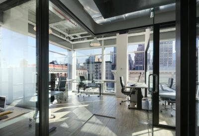 Spacious sunlit office suite with glass walls and skyline views.