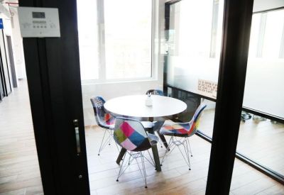 Small meeting room with a round table and colorful patchwork chairs.