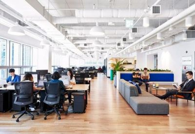 Bright, high-ceilinged open-plan workspace at 438, King Street West featuring desks and lounge areas.