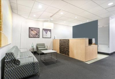 Reception area featuring a wood-fronted desk and comfortable patterned sofa.
